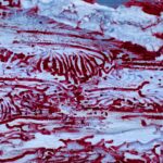 a close up of a red and white painting