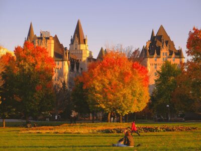a group of people sitting in a field in front of a castle