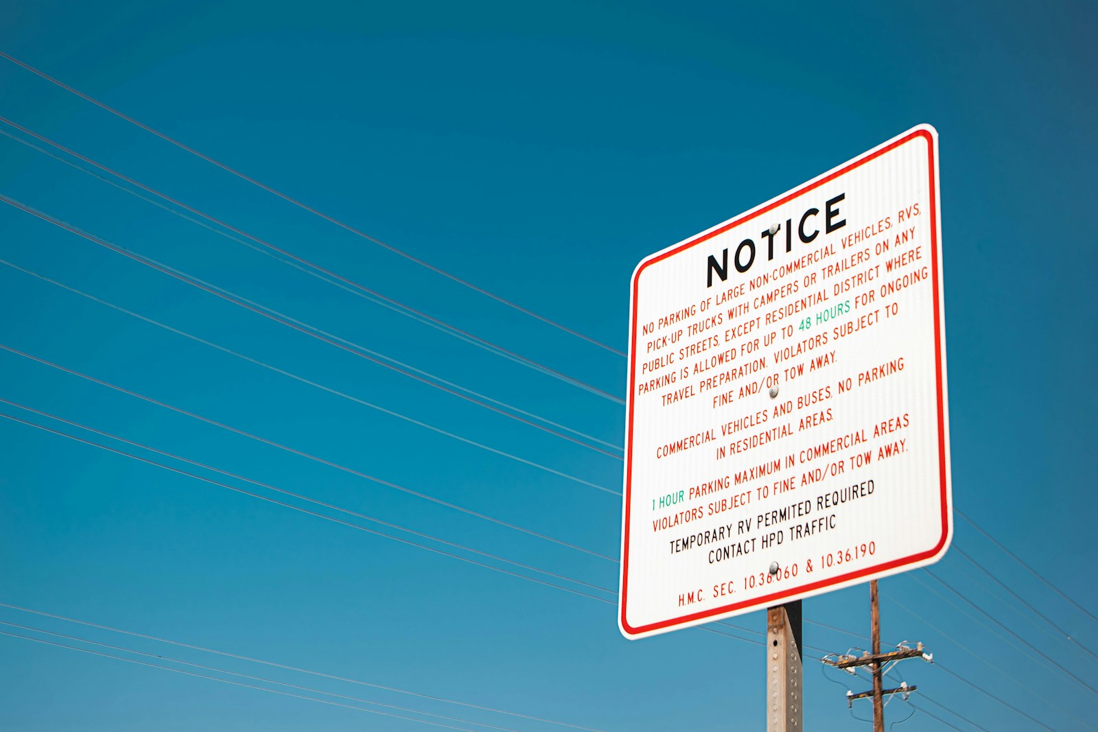 a red and white sign sitting on the side of a road